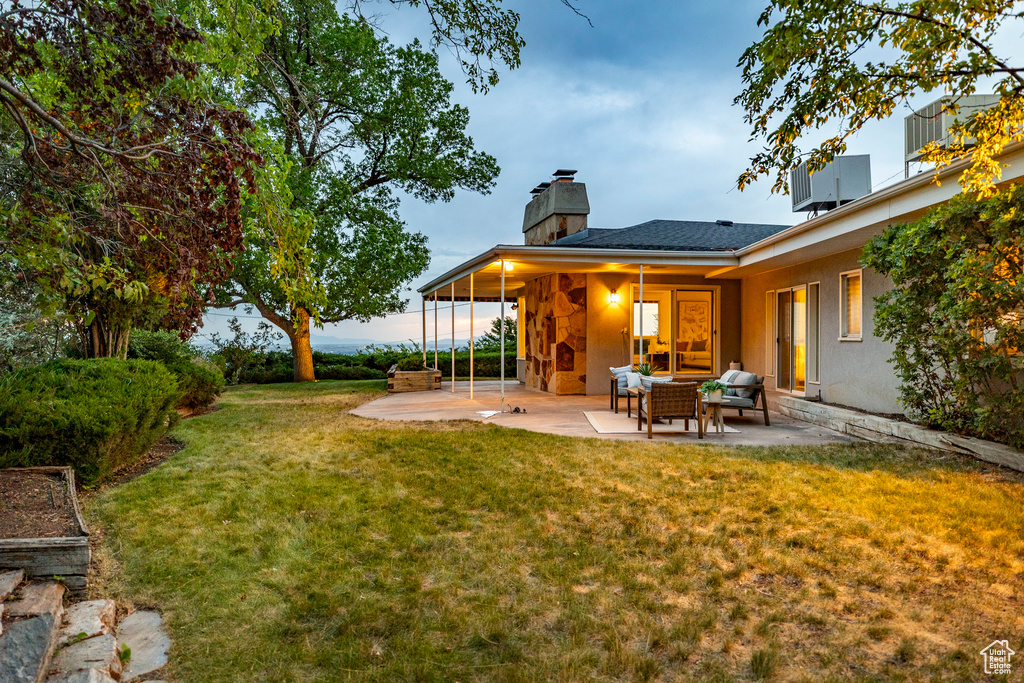 View of green lawn with a patio area