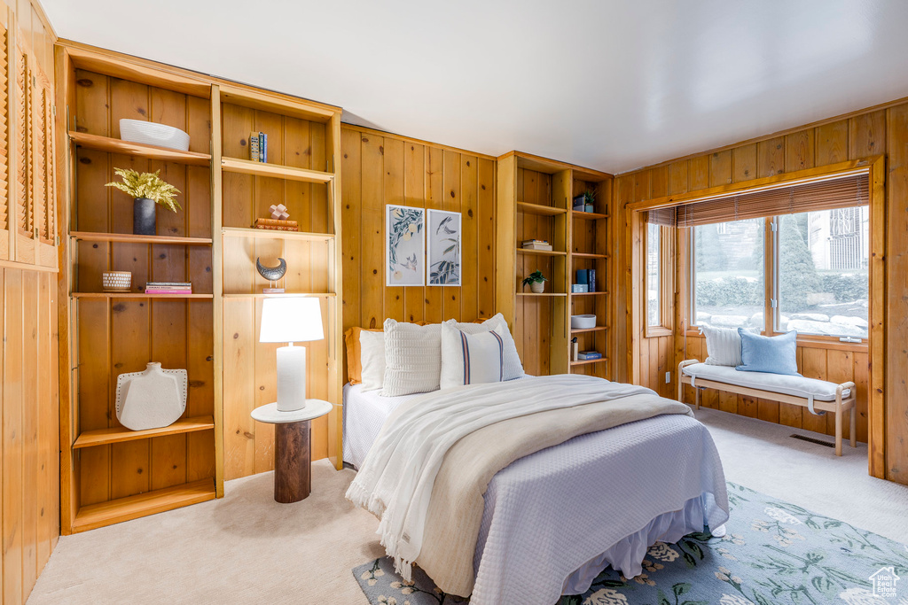 Bedroom featuring carpet flooring and wooden walls