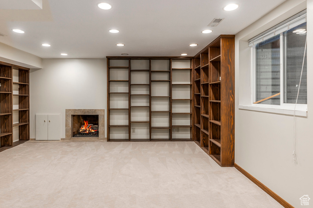 Basement featuring recessed lighting, light carpet, and a premium fireplace