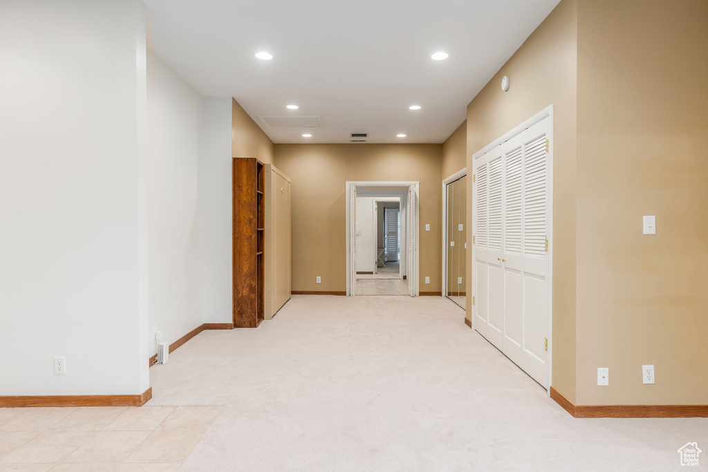 Corridor with recessed lighting and light carpet
