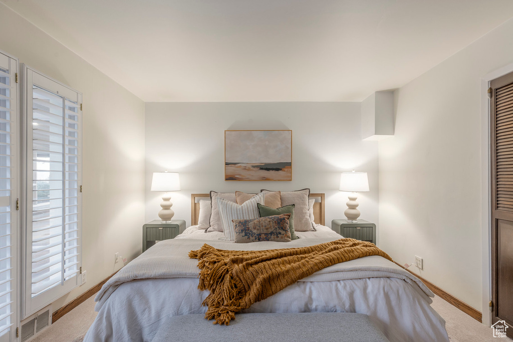 Carpeted bedroom with multiple windows