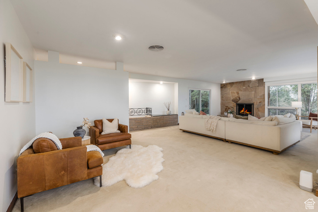 Carpeted living room with a large fireplace and recessed lighting
