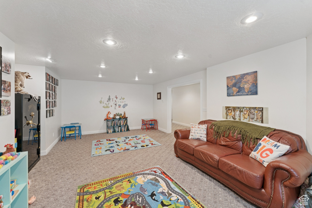 Carpeted living room featuring recessed lighting and a textured ceiling