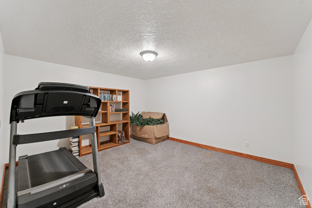 Exercise area featuring carpet and a textured ceiling