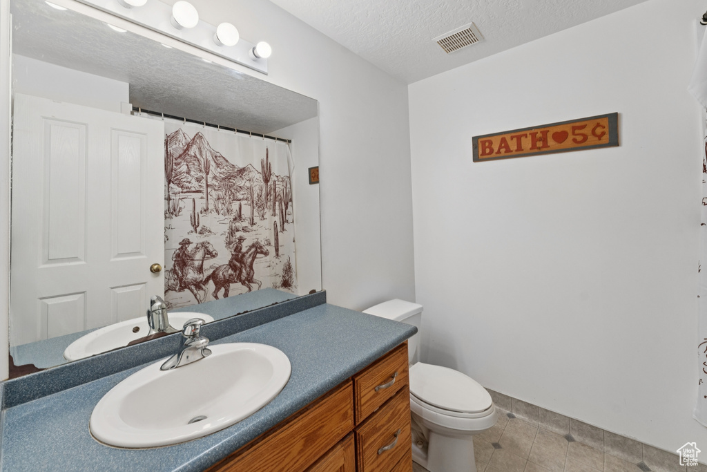 Full bathroom with vanity, a textured ceiling, tile patterned flooring, and a shower with curtain