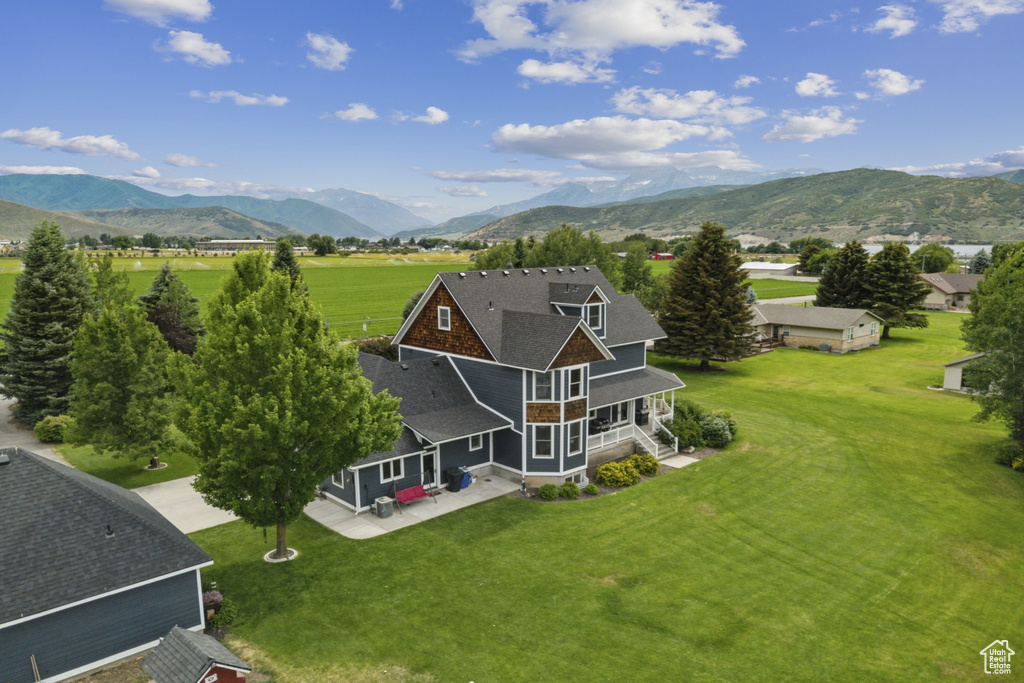 Aerial view of property and surrounding area featuring a mountainous background