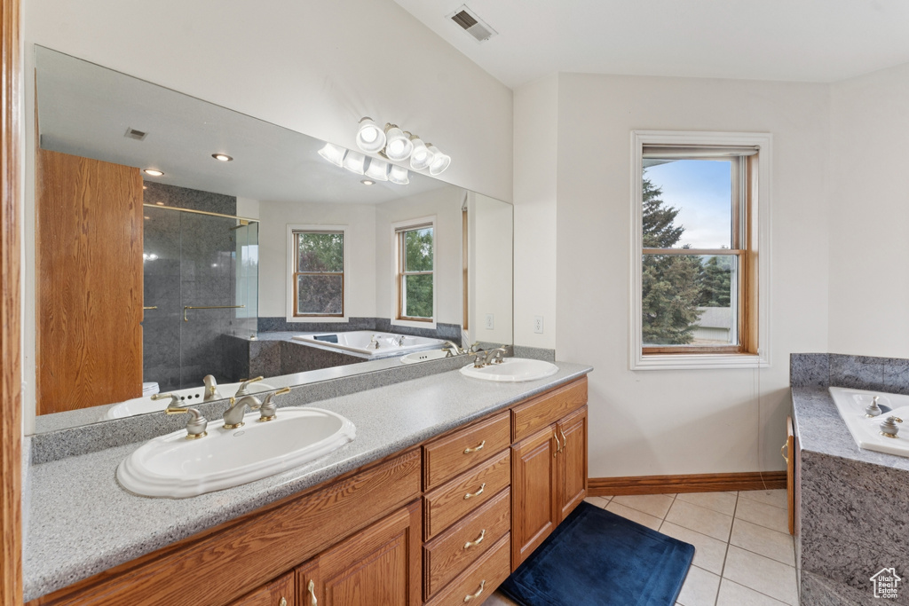 Full bathroom featuring a stall shower, a garden tub, tile patterned flooring, and double vanity