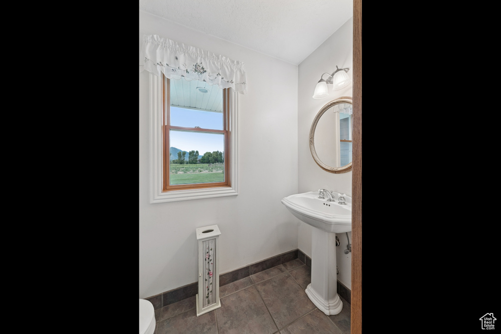 Half bath with tile patterned floors and toilet