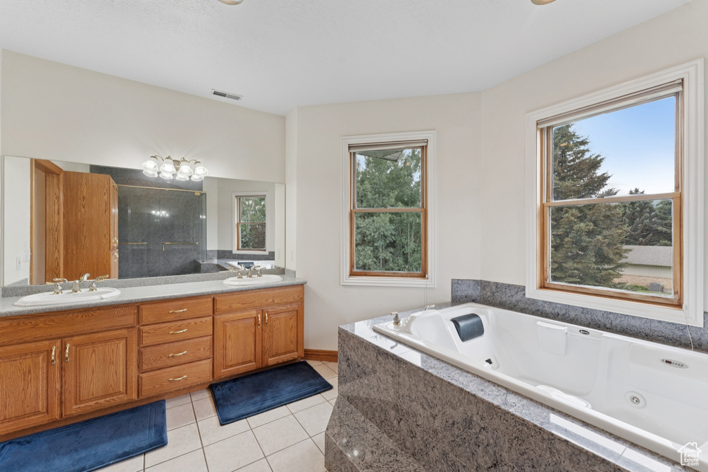 Full bath featuring tile patterned flooring, double vanity, and a jetted tub
