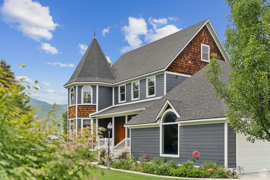 View of front facade featuring roof with shingles, a mountain view, and an attached garage