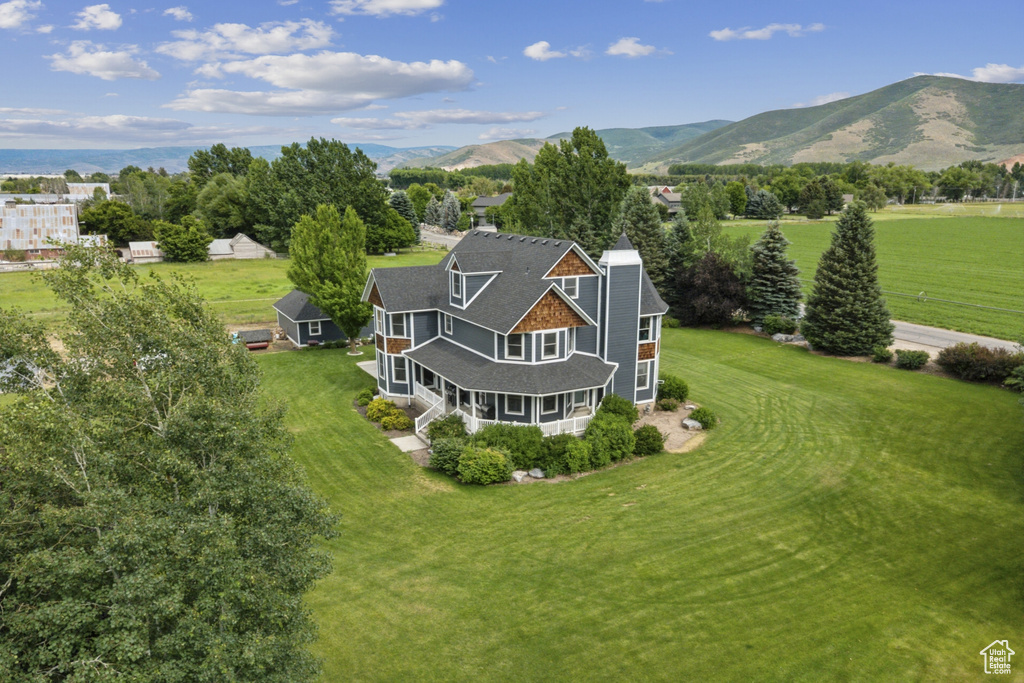 Aerial view of property and surrounding area with a mountain backdrop