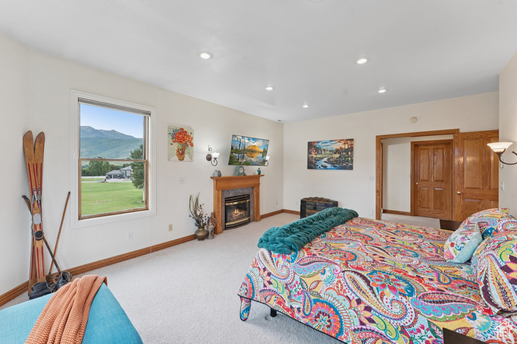 Carpeted bedroom with recessed lighting and a high end fireplace
