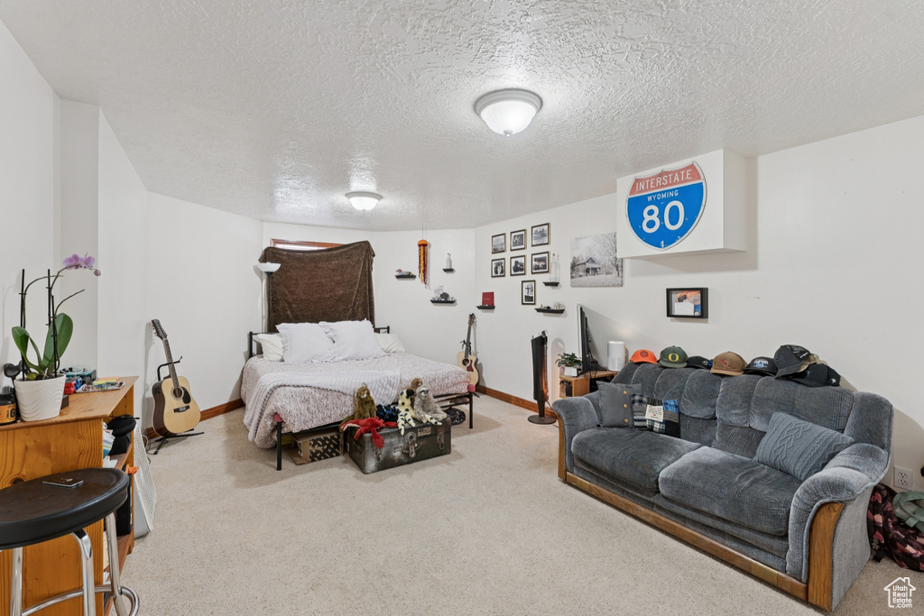 Carpeted bedroom with a textured ceiling and baseboards