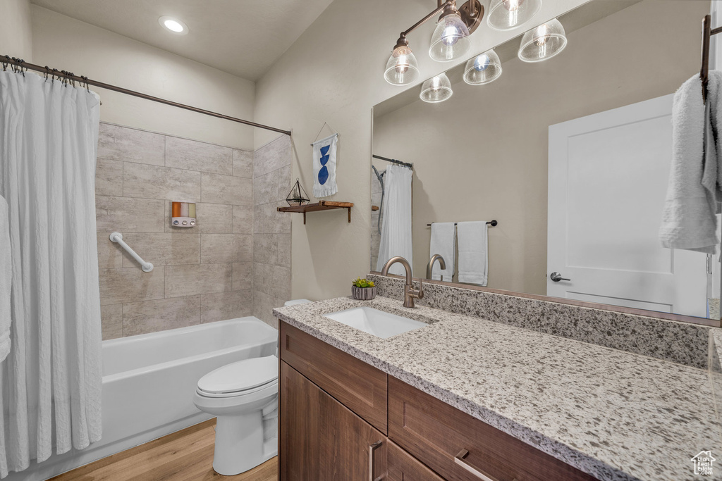 Full bathroom featuring vanity, shower / bath combination with curtain, wood finished floors, and recessed lighting