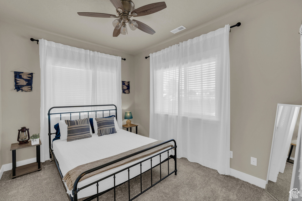 Bedroom featuring light carpet and a ceiling fan