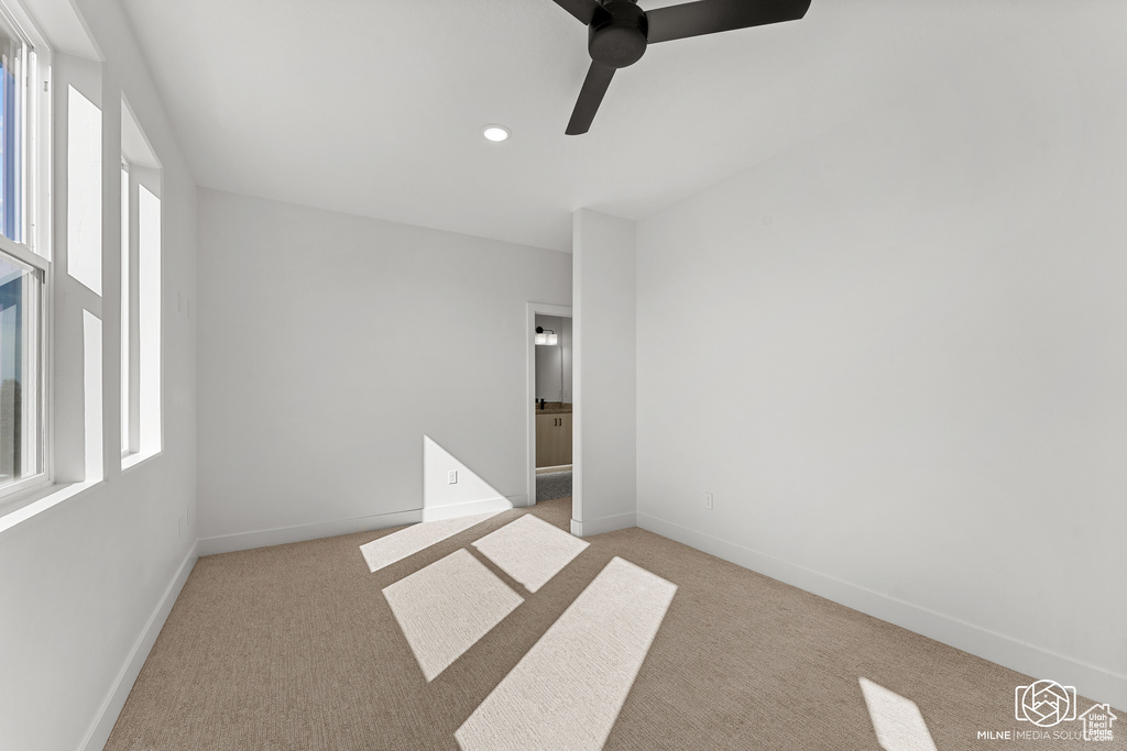 Spare room with ceiling fan, plenty of natural light, light colored carpet, and recessed lighting