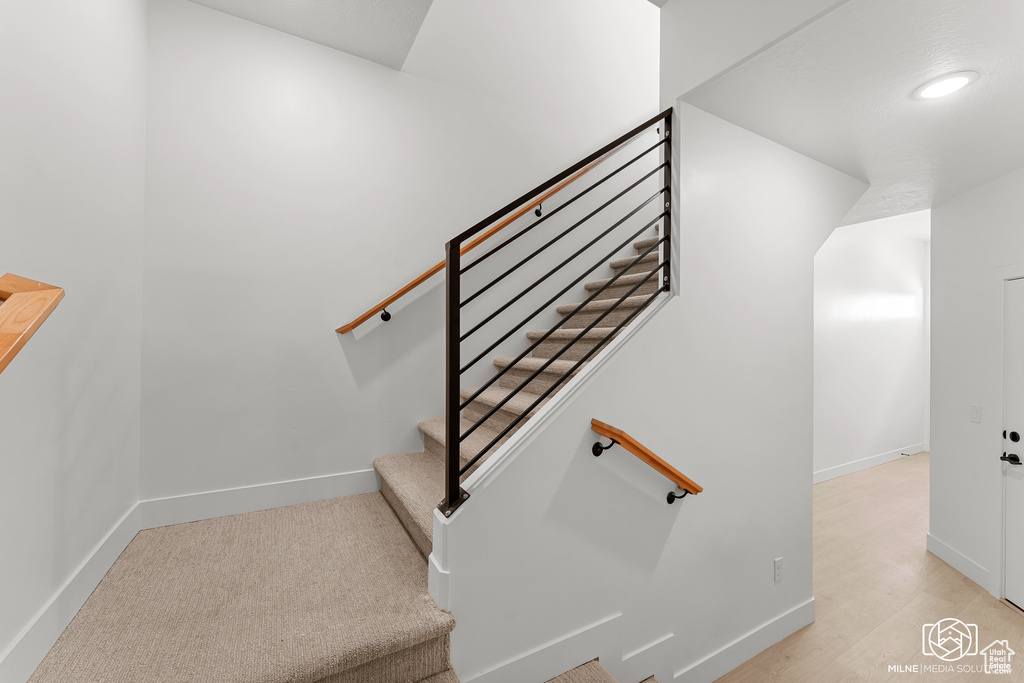 Staircase featuring recessed lighting and wood finished floors