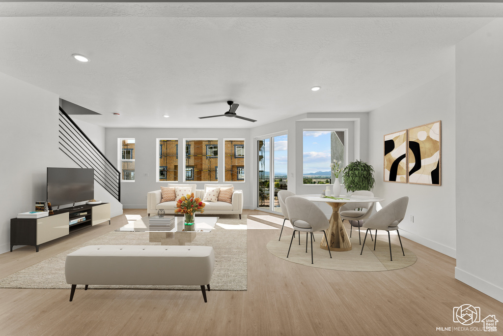 Living room with plenty of natural light, wood finished floors, ceiling fan, and recessed lighting