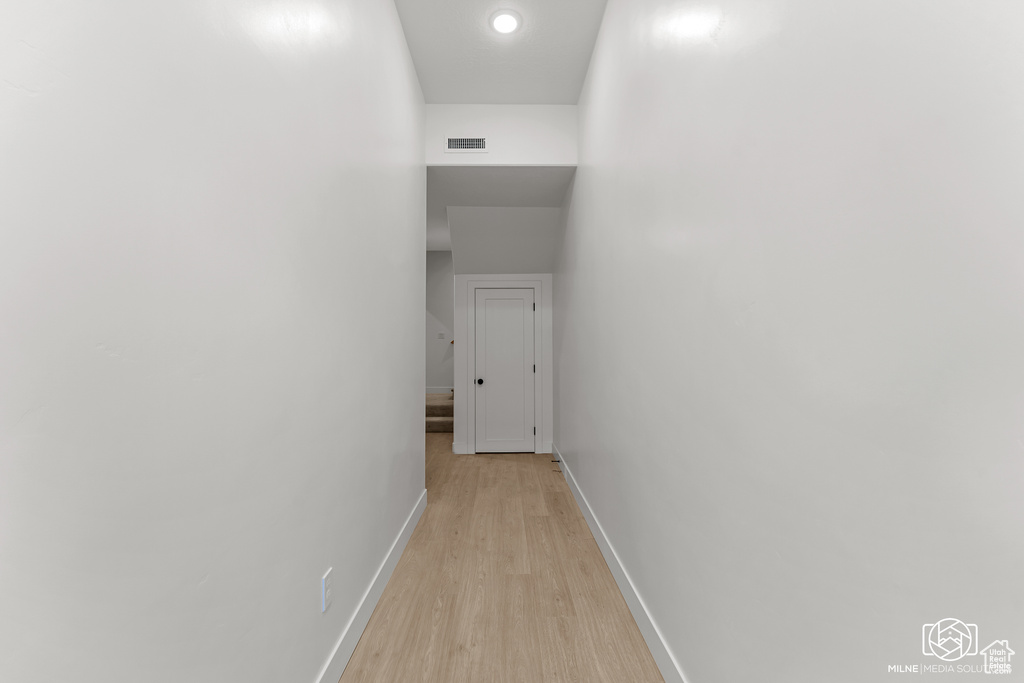 Corridor featuring light wood-type flooring and recessed lighting