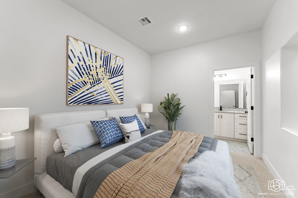 Bedroom featuring light colored carpet, ensuite bath, and recessed lighting