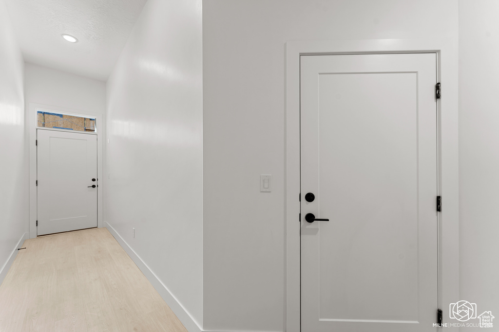 Corridor with light wood finished floors and recessed lighting