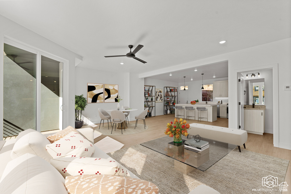 Living area with light wood-style flooring, ceiling fan, and recessed lighting
