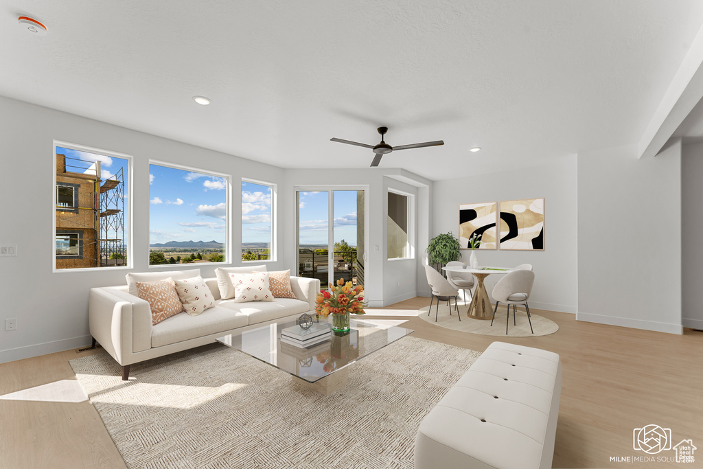 Living room with light wood-style floors, a ceiling fan, and recessed lighting