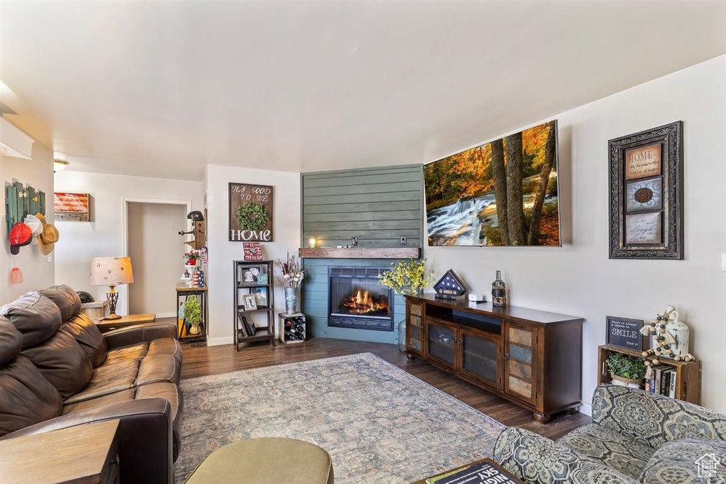 Living room featuring a lit fireplace and wood finished floors