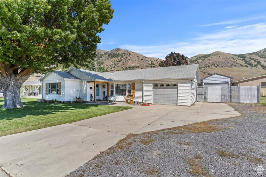 Single story home featuring a mountain view, a garage, driveway, and a gate