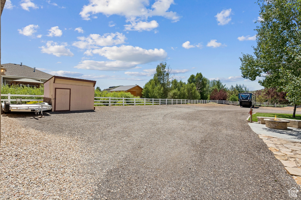 View of yard with a shed and a fire pit