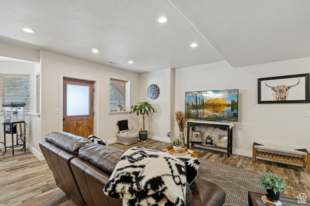 Living room with wood finished floors, recessed lighting, and healthy amount of natural light