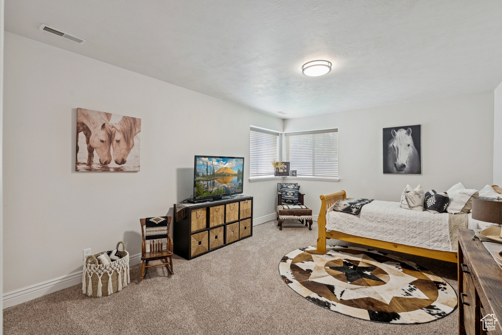 Bedroom featuring carpet and baseboards