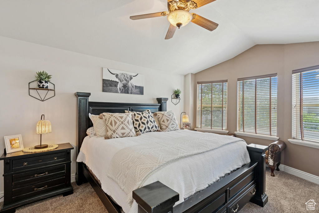 Carpeted bedroom with vaulted ceiling and ceiling fan