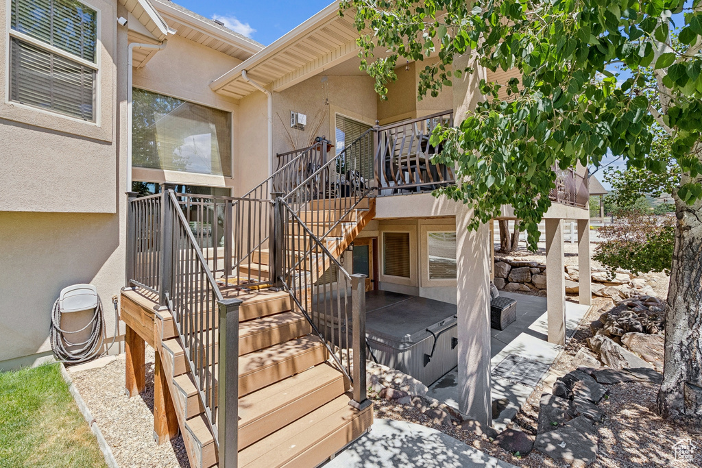 Entrance to property with stucco siding, a patio area, and a hot tub