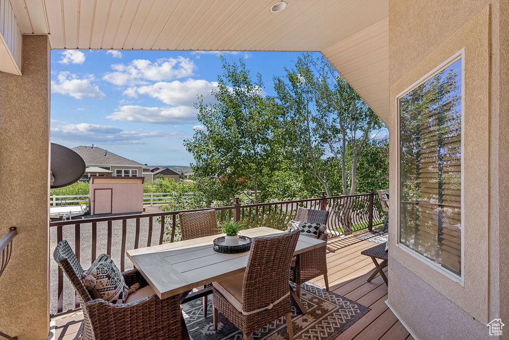 Wooden terrace with outdoor dining area and a storage shed