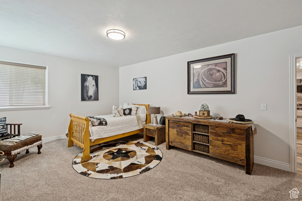 Bedroom featuring carpet flooring and baseboards