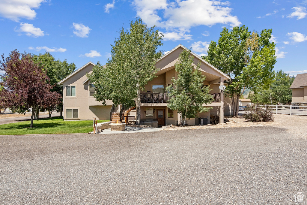 View of property hidden behind natural elements with stucco siding