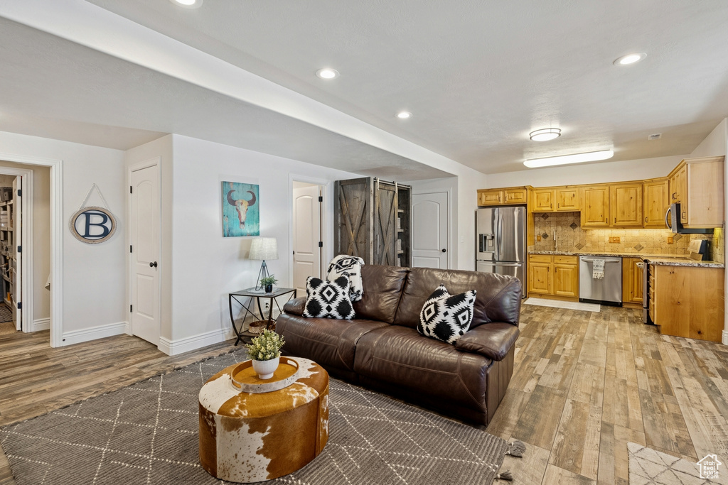 Living area with light wood-style flooring and recessed lighting