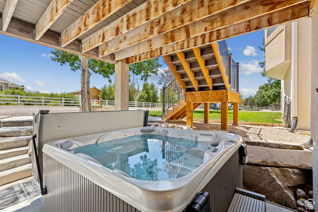View of patio / terrace with a hot tub and stairs