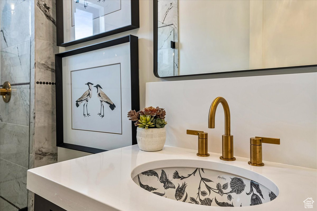 Bathroom view of vanity and tiled shower
