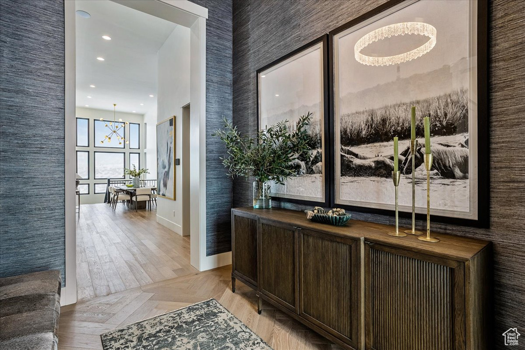 Corridor featuring recessed lighting, a chandelier, and light wood-style flooring