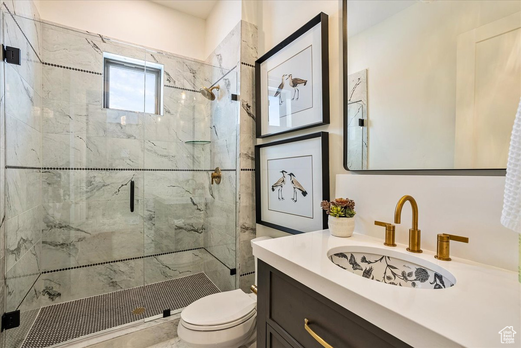 Bathroom featuring a marble finish shower and vanity