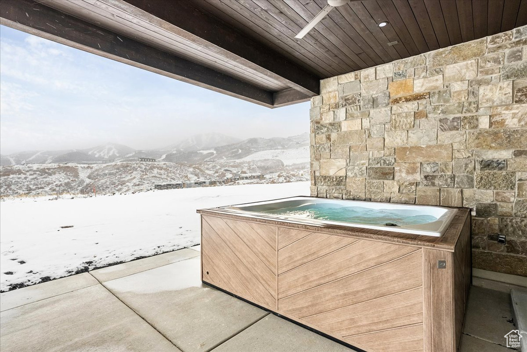 View of patio / terrace with a hot tub and a mountain view