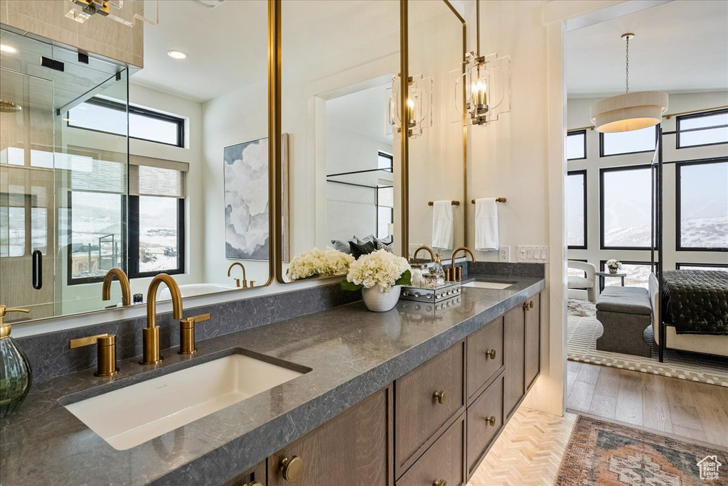 Ensuite bathroom with double vanity, a shower stall, and recessed lighting
