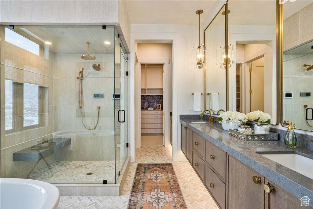 Bathroom featuring a shower stall, double vanity, and a tub