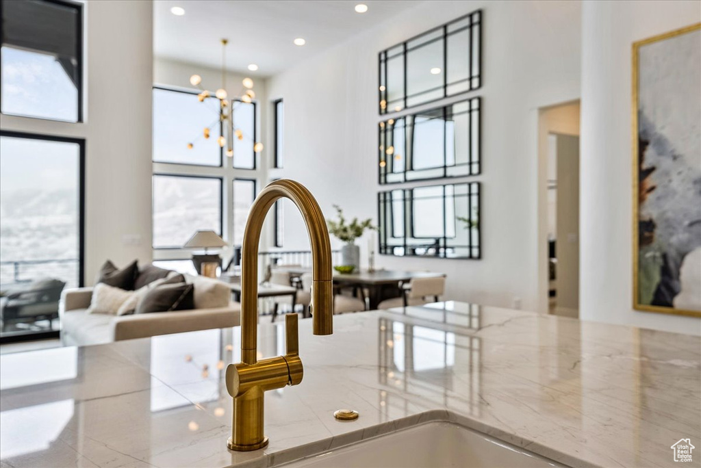 Kitchen view of recessed lighting, a chandelier, and light stone counters