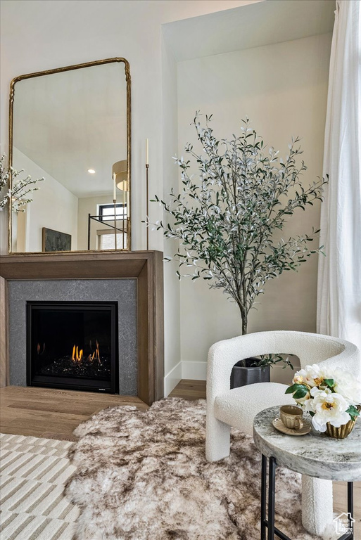 Sitting room featuring a warm lit fireplace and wood finished floors