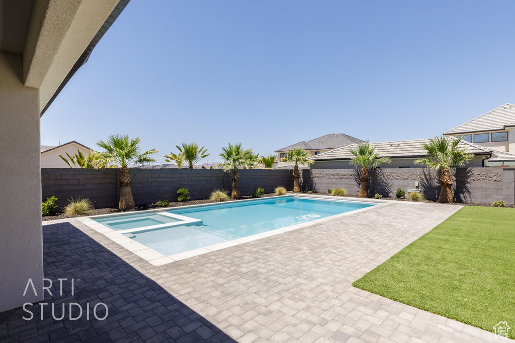 View of swimming pool with a fenced backyard, a patio area, and a pool with connected hot tub