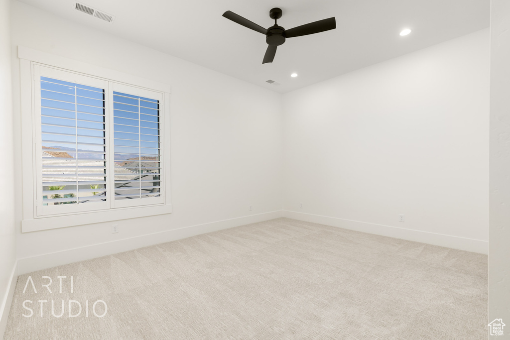 Carpeted empty room with a ceiling fan and recessed lighting