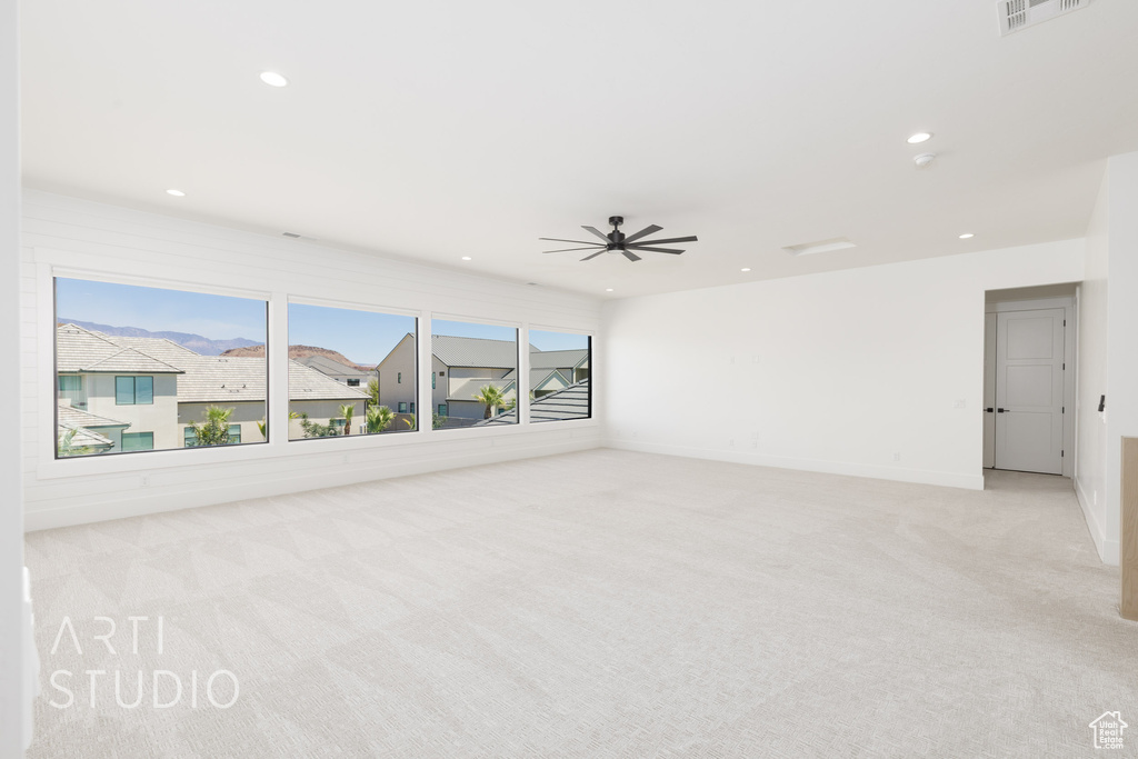 Spare room featuring light carpet, recessed lighting, and a ceiling fan